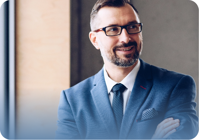 Homem de negócios sorridente usando terno azul e óculos, transmitindo confiança e profissionalismo.